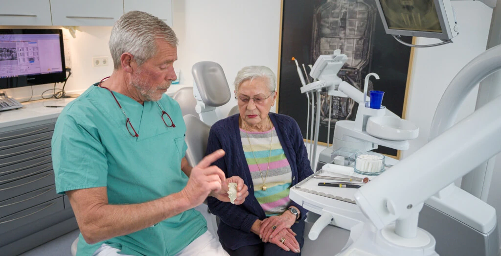 Zahnarzt berät Patientin zu Implantaten in Berlin