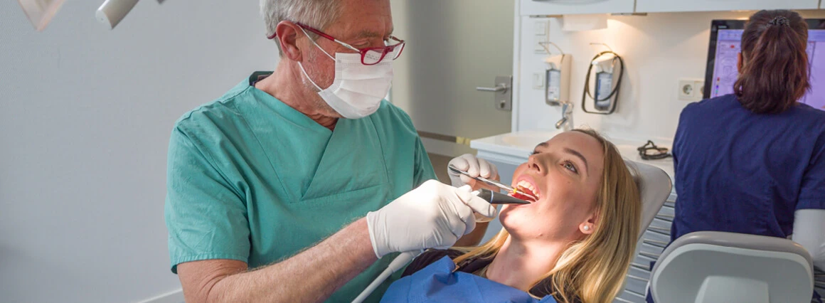 Zahnarzt bei der Weisheitszahnentfernung einer Patientin