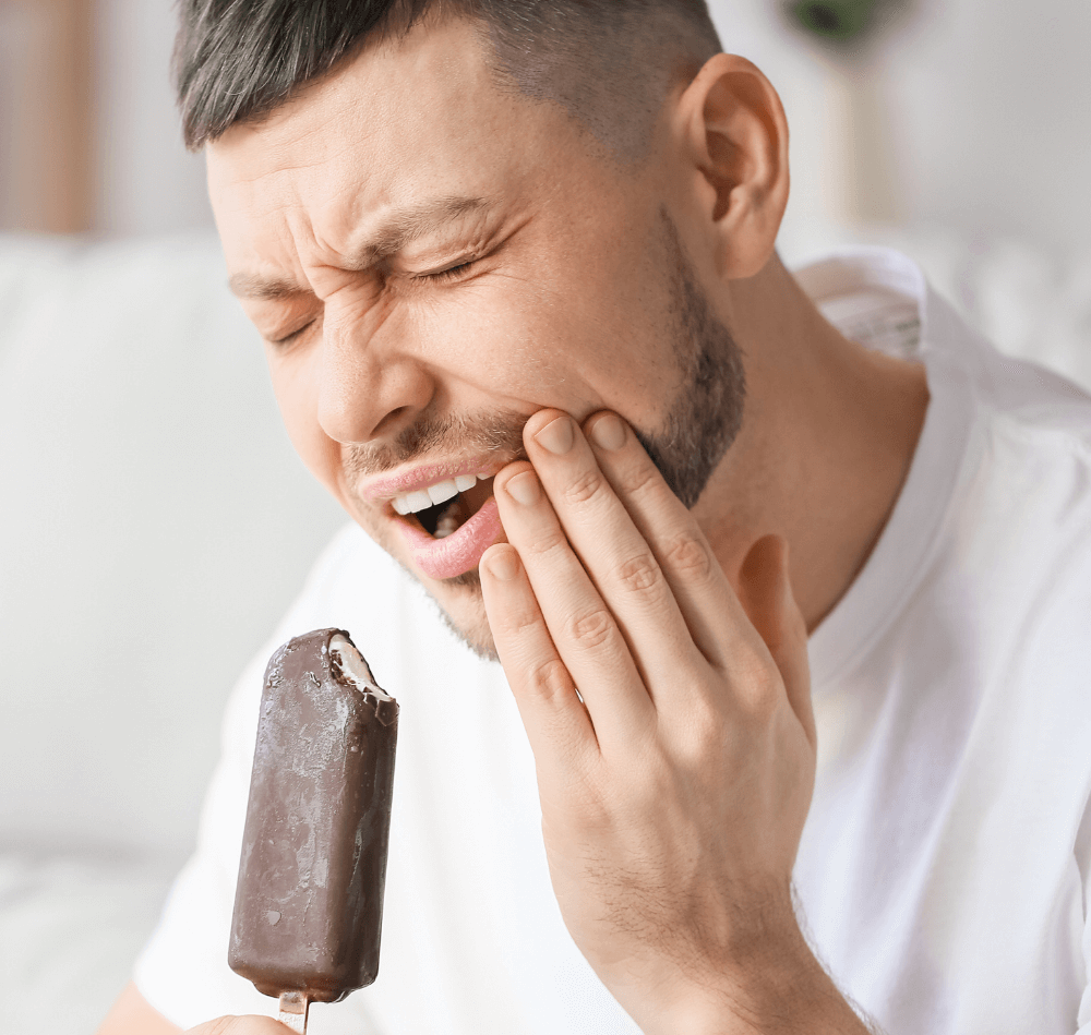 Person hat Schmerzen, da die Zähne empfindlich auf das Eis reagieren.